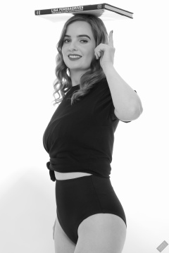 Harriet in black T-shirt, tied at the waist, with black control briefs worn as hotpants