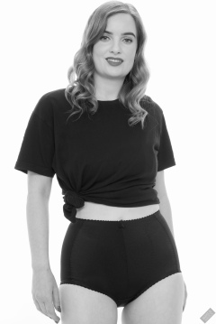 Harriet in black T-shirt, tied at the waist, with black control briefs worn as hotpants