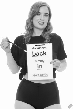 Harriet in black T-shirt, tied at the waist, with black control briefs worn as hotpants