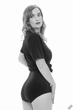 Harriet in black T-shirt, tied at the waist, with black control briefs worn as hotpants