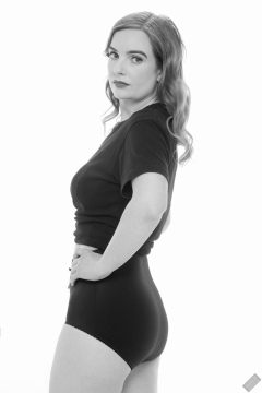 Harriet in black T-shirt, tied at the waist, with black control briefs worn as hotpants