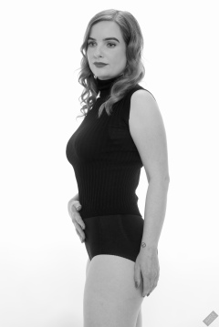 Harriet in black T-shirt, tied at the waist, with black control briefs worn as hotpants