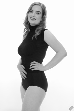 Harriet in black T-shirt, tied at the waist, with black control briefs worn as hotpants