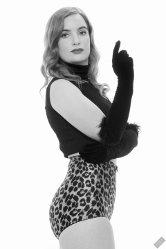 Harriet in black stretchy top and retro-style animal-print control-briefs worn as hotpants