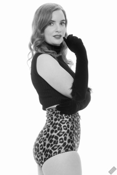 Harriet in black stretchy top and retro-style animal-print control-briefs worn as hotpants