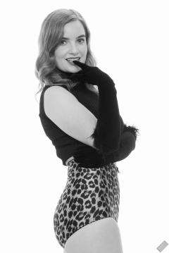 Harriet in black stretchy top and retro-style animal-print control-briefs worn as hotpants