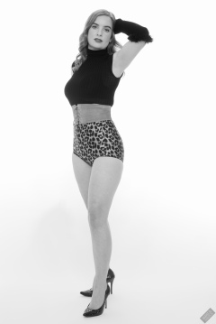 Harriet in black stretchy top, tight leather corset belt and retro-style animal-print control-briefs worn as hotpants