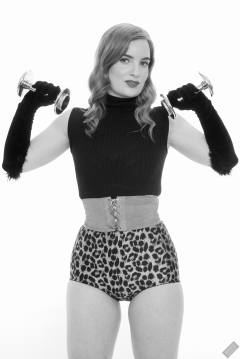 Harriet in black stretchy top, tight leather corset belt and retro-style animal-print control-briefs worn as hotpants