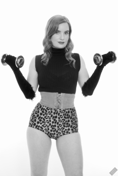 Harriet in black stretchy top, tight leather corset belt and retro-style animal-print control-briefs worn as hotpants