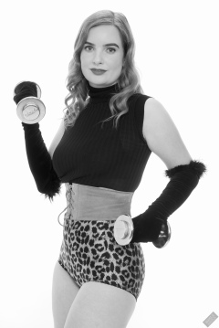 Harriet in black stretchy top, tight leather corset belt and retro-style animal-print control-briefs worn as hotpants
