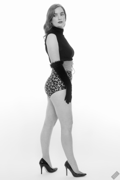Harriet in black stretchy top, tight leather corset belt and retro-style animal-print control-briefs worn as hotpants