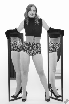 Harriet in black stretchy top, tight leather corset belt and retro-style animal-print control-briefs worn as hotpants