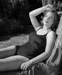 Harriet enjoys the sunshine in blue vintage one-piece swimsuit