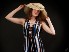 Estella Rose in her own vertical-striped jump suit and straw hat