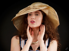 Estella Rose in her own vertical-striped jump suit and straw hat