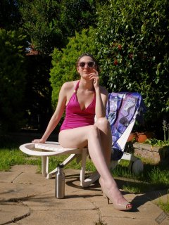 Estella Rose in purple swimsuit exercising in the garden