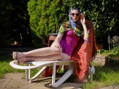 Estella Rose in purple swimsuit exercising in the garden