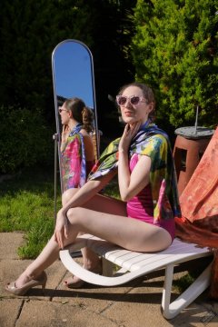 Estella Rose in purple swimsuit exercising in the garden