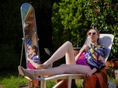 Estella Rose in purple swimsuit exercising in the garden