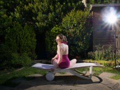 Estella Rose in purple swimsuit exercising in the garden