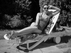 Estella Rose in purple swimsuit exercising in the garden