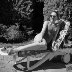 Estella Rose in purple swimsuit exercising in the garden