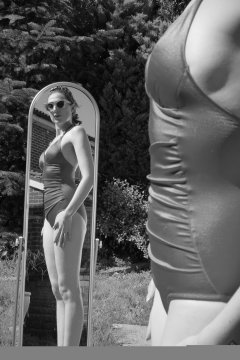 Estella Rose in purple swimsuit exercising in the garden