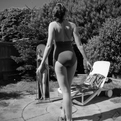 Estella Rose in purple swimsuit exercising in the garden