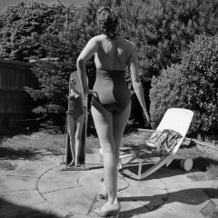 Estella Rose in purple swimsuit exercising in the garden