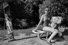 Estella Rose in purple swimsuit exercising in the garden