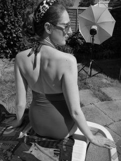 Estella Rose in purple swimsuit exercising in the garden