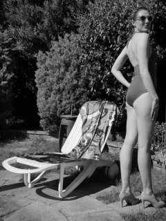 Estella Rose in purple swimsuit exercising in the garden