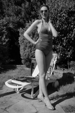 Estella Rose in purple swimsuit exercising in the garden