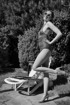 Estella Rose in purple swimsuit exercising in the garden