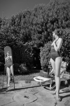 Estella Rose in purple swimsuit exercising in the garden