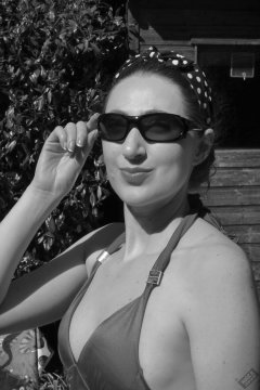 Estella Rose in purple swimsuit exercising in the garden