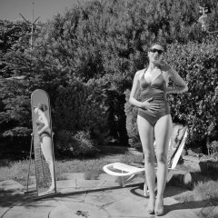 Estella Rose in purple swimsuit exercising in the garden