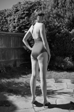 Estella Rose in purple swimsuit exercising in the garden