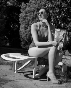 Estella Rose in purple swimsuit exercising in the garden