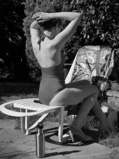 Estella Rose in purple swimsuit exercising in the garden
