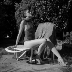 Estella Rose in purple swimsuit exercising in the garden