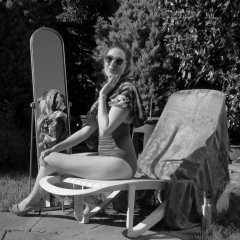 Estella Rose in purple swimsuit exercising in the garden