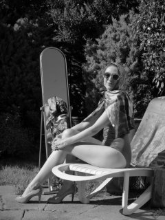 Estella Rose in purple swimsuit exercising in the garden