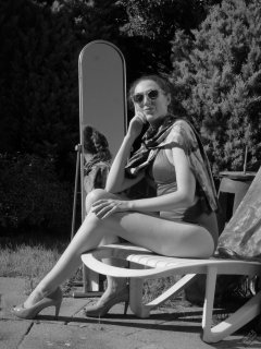 Estella Rose in purple swimsuit exercising in the garden