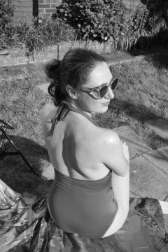 Estella Rose in purple swimsuit exercising in the garden