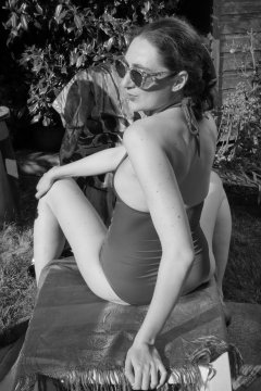 Estella Rose in purple swimsuit exercising in the garden