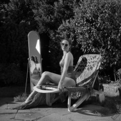 Estella Rose in purple swimsuit exercising in the garden