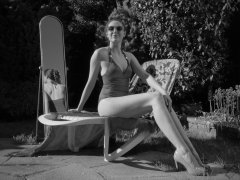 Estella Rose in purple swimsuit exercising in the garden