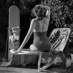 Estella Rose in purple swimsuit exercising in the garden