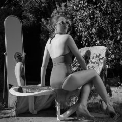 Estella Rose in purple swimsuit exercising in the garden